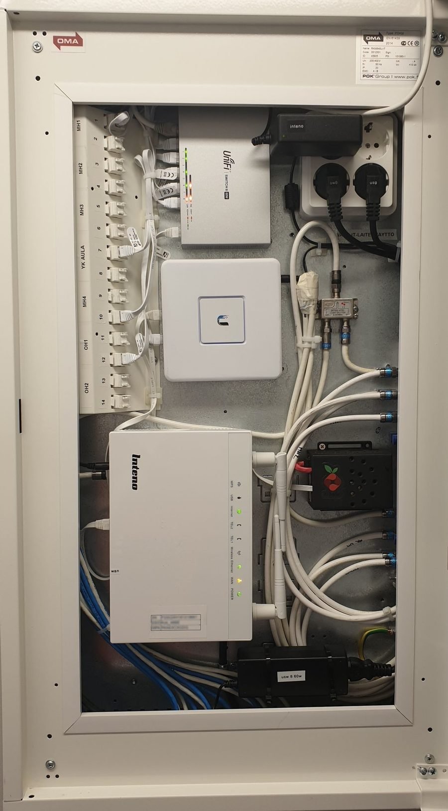 Structured wiring enclosure with every room's Ethernet run terminated and labeled on a punch-down block, feeding a UniFi switch and access point